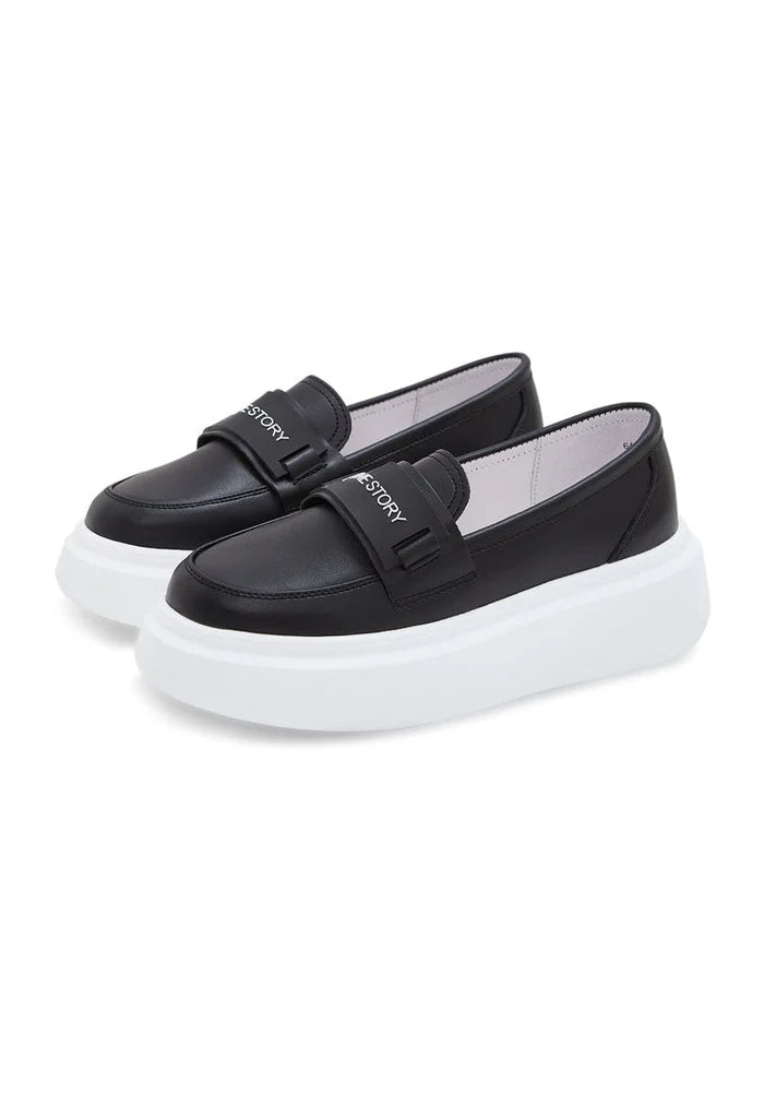 A fashionable pair of slip-on black loafers with platform soles for women, perfect for the latest trend in fashion footwear.