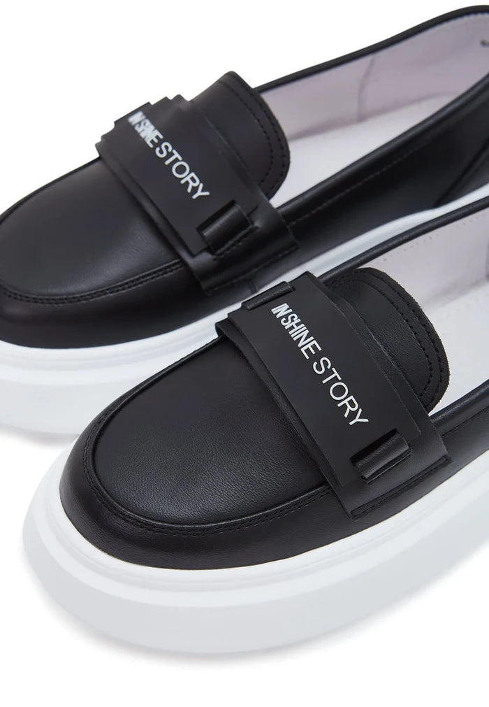 A stylish pair of black slip-on platform loafers for women, the perfect fashion footwear choice.