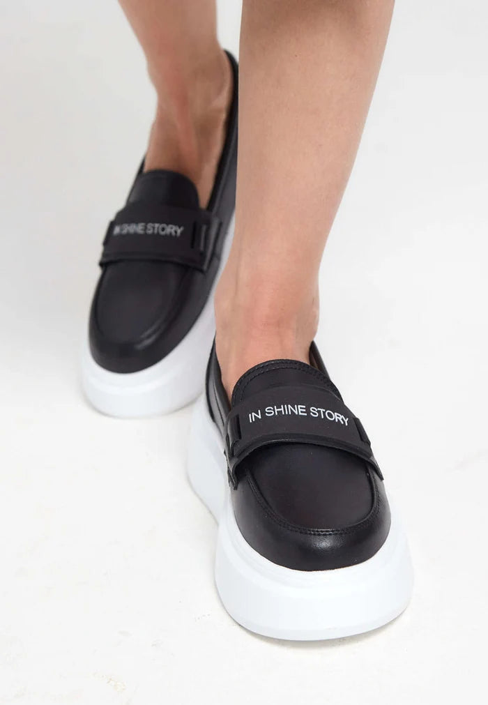 A trendy pair of women's slip-on loafers in black, featuring a platform sole for fashionable and comfortable all-day wear.