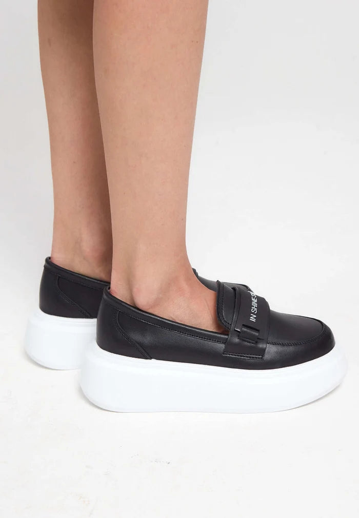 A stylish pair of women's black slip-on platform loafers, perfect for fashionable footwear looks.