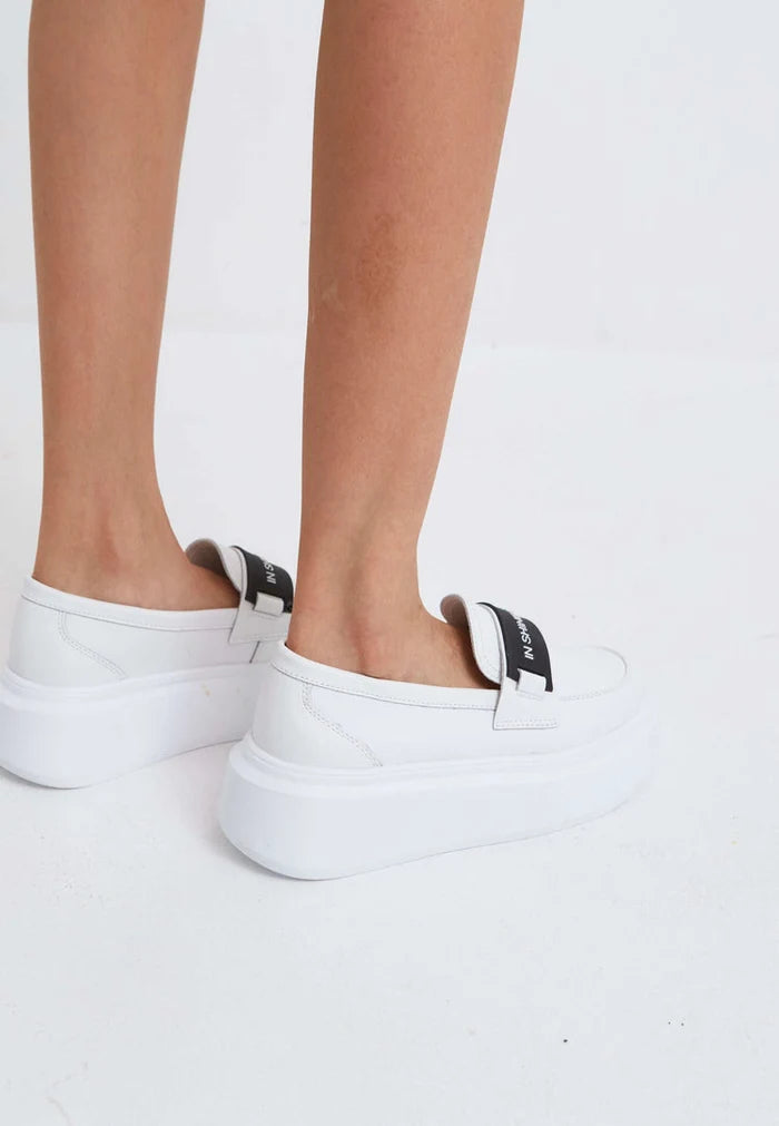 A stylish pair of slip-on platform shoes in white, perfect for women's casual footwear.