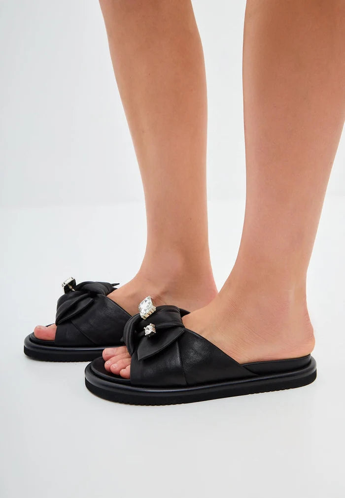 A close-up image of trendy black platform slippers with a stylish design, known as Fernanda slippers, perfect women's footbed sandals for a trendy look.