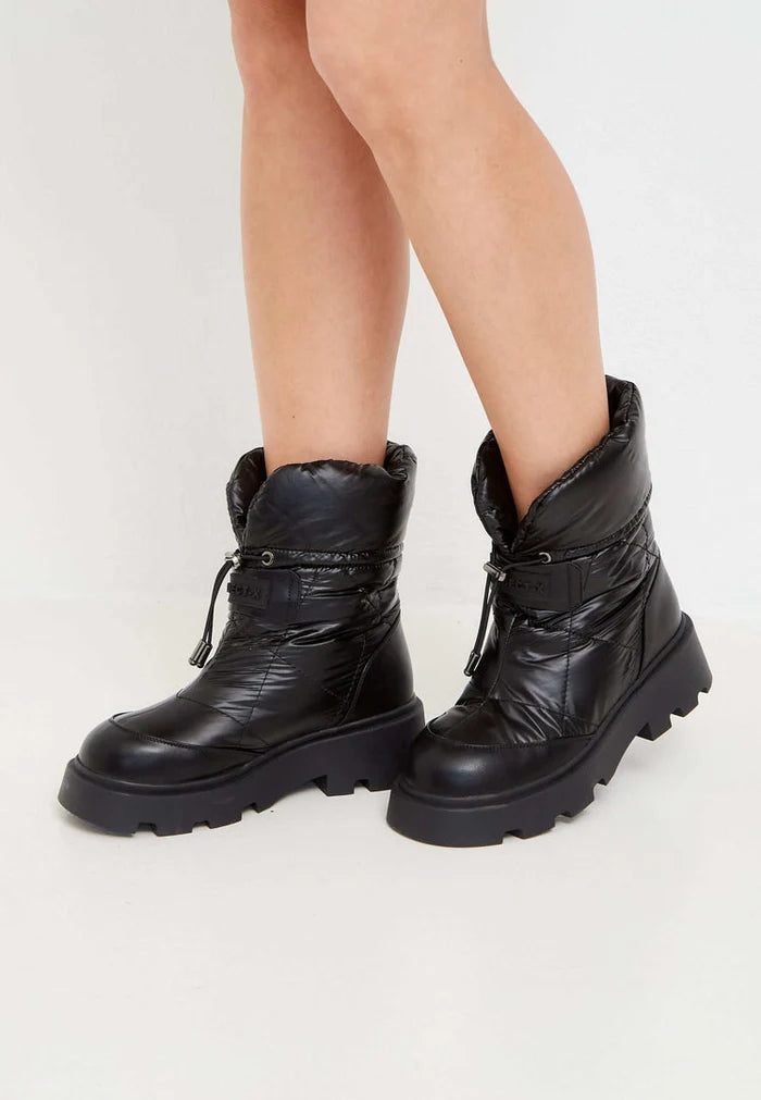 A pair of stylish black quilted winter snow boots for women, ideal for staying warm and fashionable in the snow.