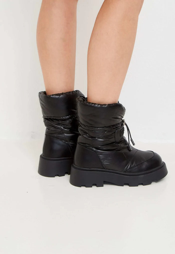 A pair of stylish black quilted snow boots for women, perfect for winter.