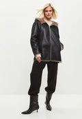A stylish and trendy reversible faux leather jacket with faux fur trim, perfect for the fashion-conscious individual looking for vegan leather outerwear with fur details.