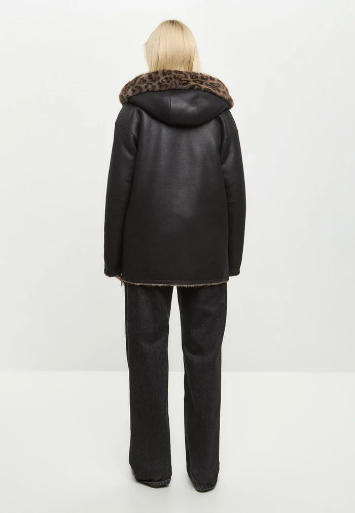 A stylish women's winter jacket in faux leather with leopard faux fur trim, offering a reversible design for versatile wear.