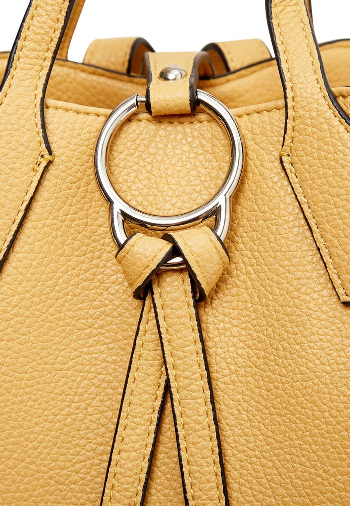 A stylish mustard leather backpack with a unique ring detail, perfect for anyone looking for a luxe and trendy accessory.
