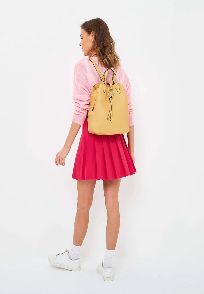 A stylish mustard leather backpack with a unique ring design, perfect for adding a touch of luxe to your outfit.