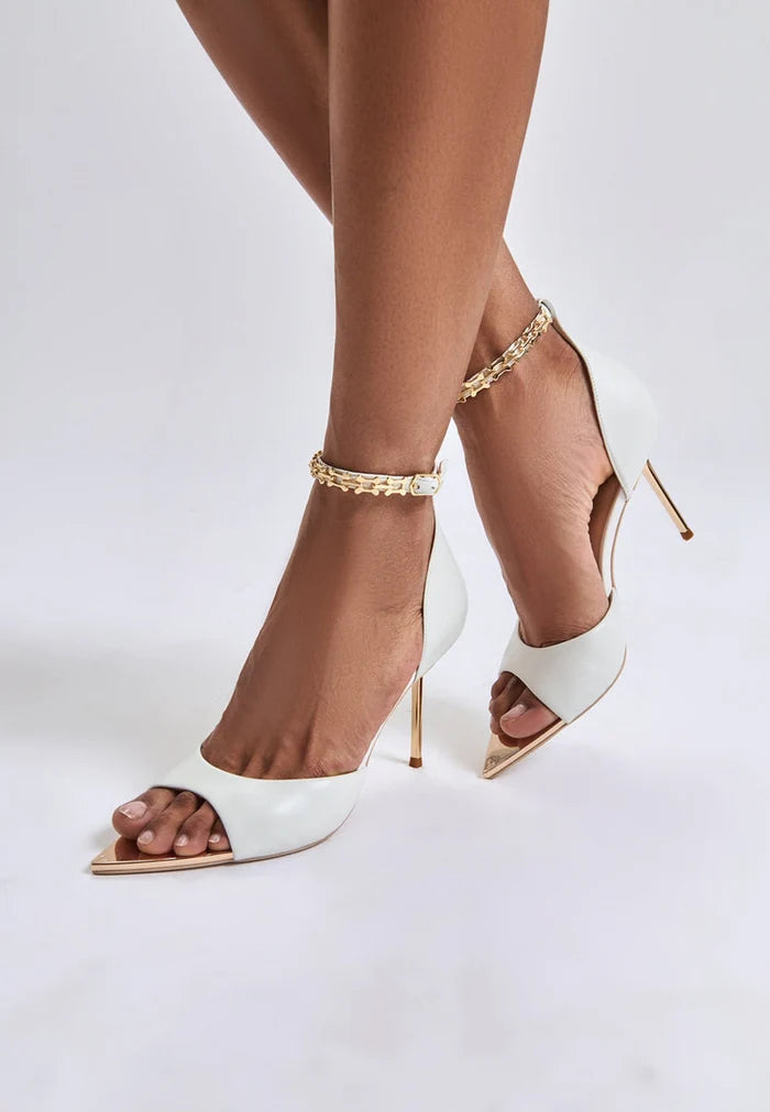 A pair of stylish white stiletto high-heeled sandals, perfect to buy online for a fashionable look.