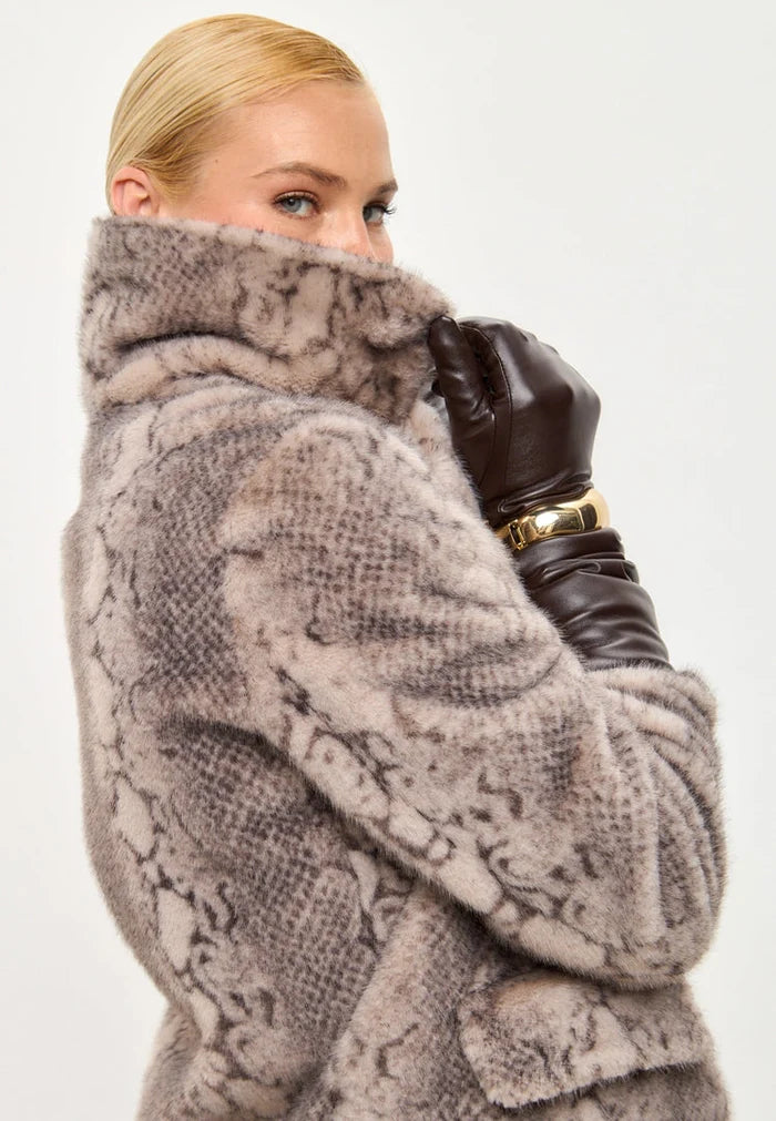A trendy winter fashion statement featuring a stylish beige faux fur Niuvis coat with snake print design.