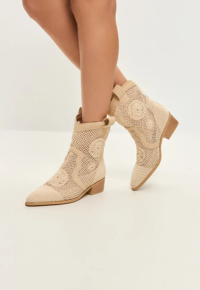 A pair of stylish beige suede cowboy boots with Western flair, designed with high-quality leather for a designer touch.
