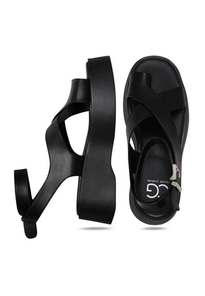 A stylish pair of women's black suede sandals with trendy cross-straps, perfect for summer fashion.