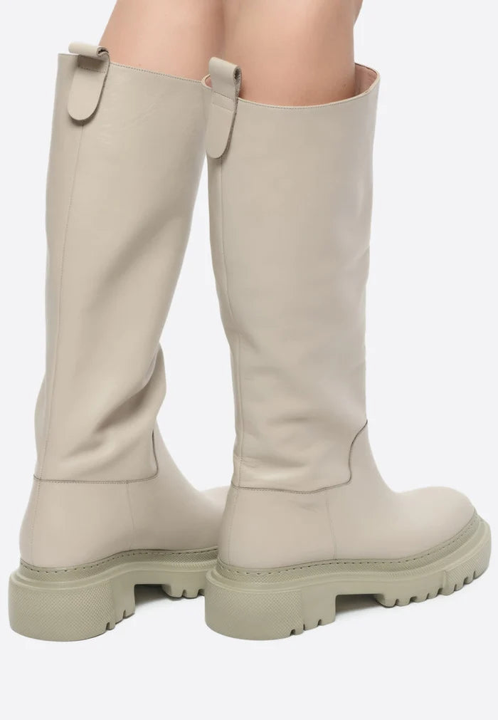 A stylish pair of women's tall leather boots with a chunky sole in beige, perfect for fashion-forward footwear looks.