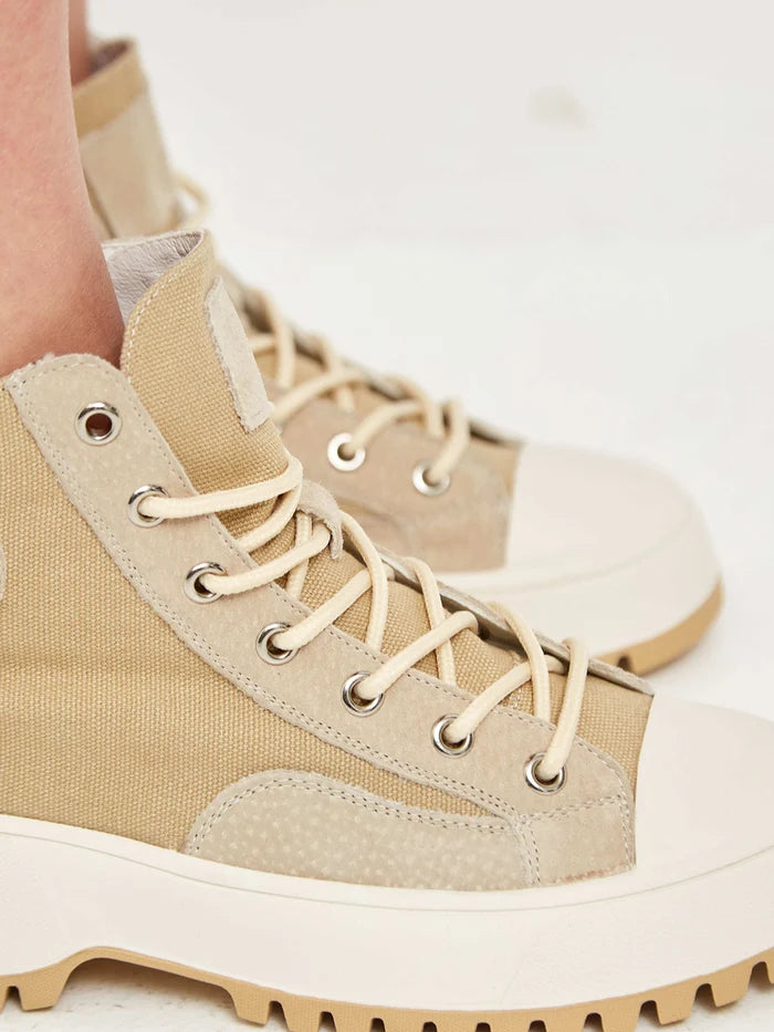 A close-up image of lace-up high top sneakers with textured detailing, perfect for a stylish and sporty look.