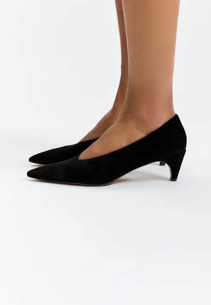 A stylish pair of black velvet curve pumps, the epitome of elegant and trendy footwear.